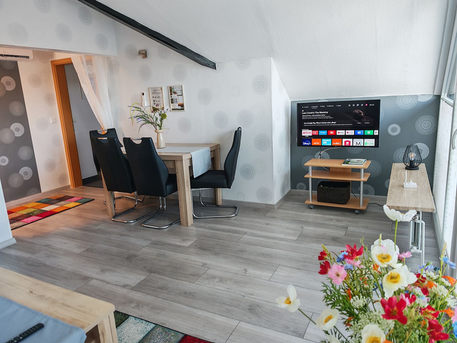 Wohnzimmer mit Sitzecke und Smart TV