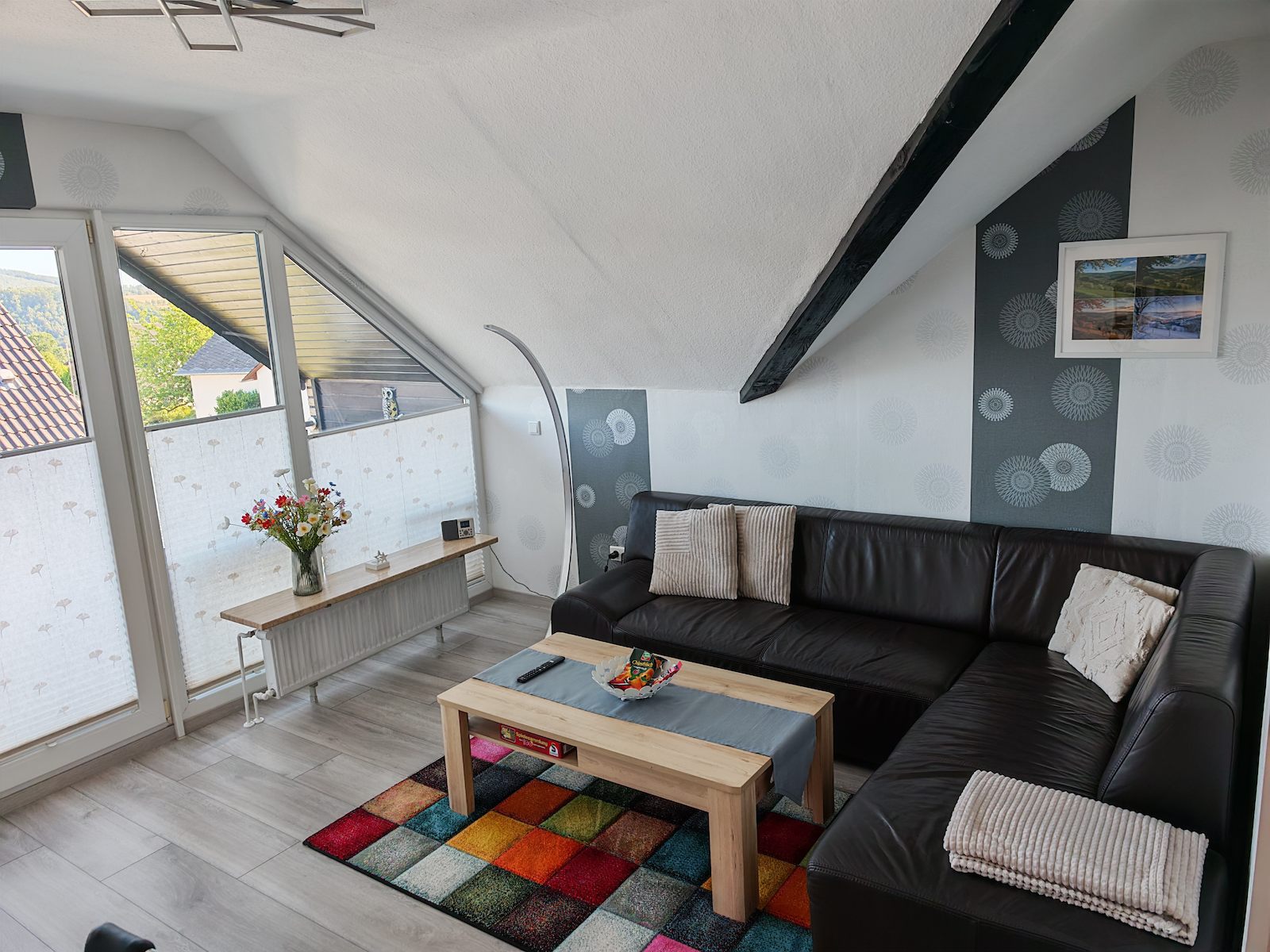 Wohnzimmer mit Sofa und Zugang zum Balkon